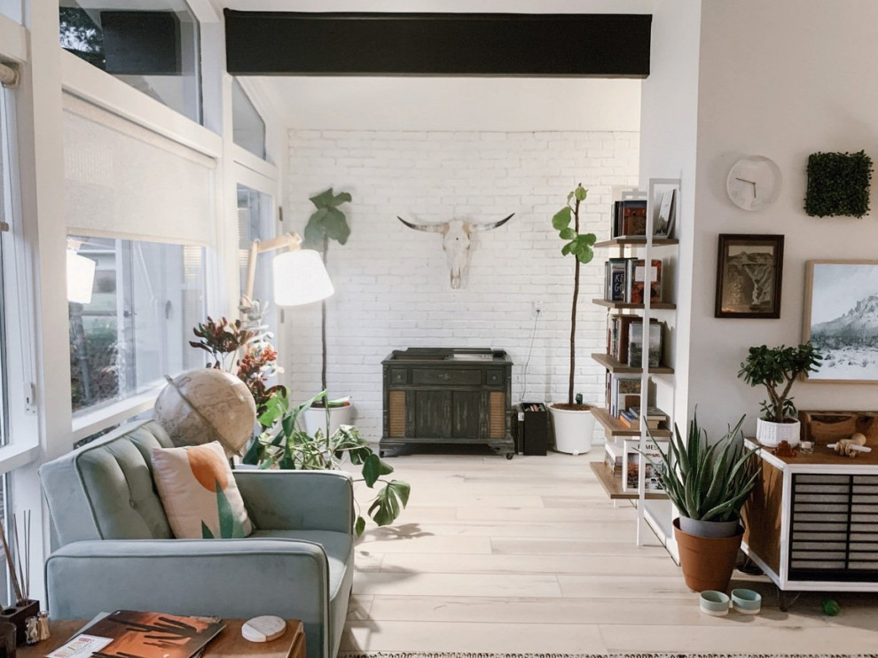 Inspiration for a mid-sized midcentury loft-style living room in Indianapolis with a library, white walls, vinyl floors, beige floor and exposed beam.