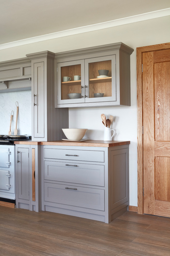 Design ideas for a large country l-shaped separate kitchen in London with an integrated sink, shaker cabinets, grey cabinets, wood benchtops, white splashback, coloured appliances, light hardwood floors and with island.