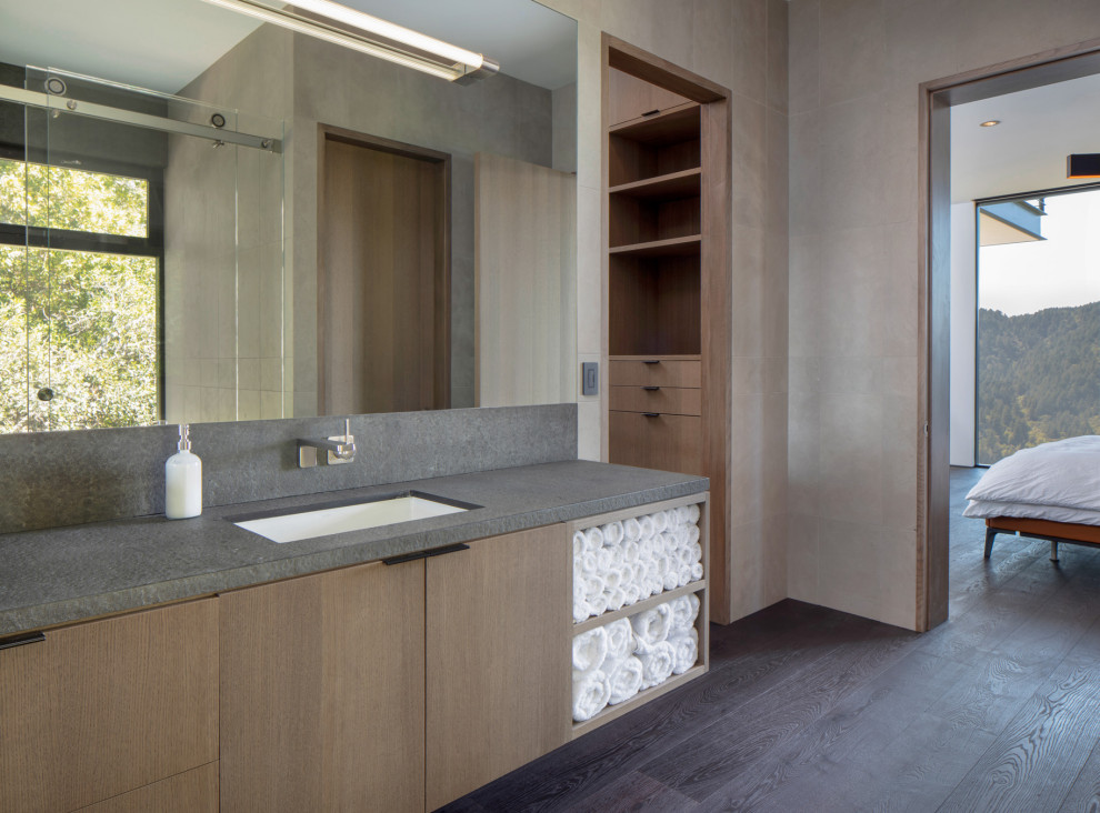 Inspiration for a mid-sized modern master bathroom in San Francisco with flat-panel cabinets, medium wood cabinets, a curbless shower, a bidet, beige tile, porcelain tile, grey walls, dark hardwood floors, an undermount sink, engineered quartz benchtops, brown floor, a sliding shower screen, grey benchtops, a single vanity and a floating vanity.