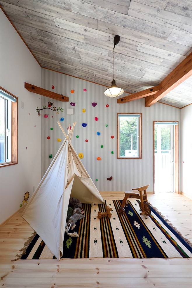 Country kids' playroom in Other with white walls, light hardwood floors and brown floor.