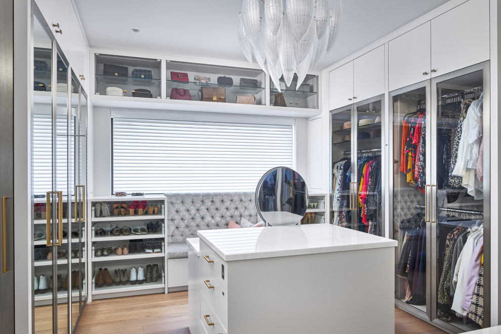 Inspiration for a mid-sized contemporary gender-neutral walk-in wardrobe in Ottawa with flat-panel cabinets, white cabinets, medium hardwood floors and beige floor.