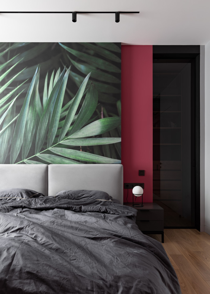 Imagen de dormitorio actual de tamaño medio con paredes multicolor, suelo de madera en tonos medios y suelo marrón