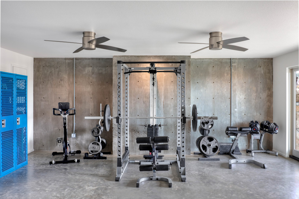 Country multi-use home gym in Austin with concrete flooring, grey floors and a feature wall.