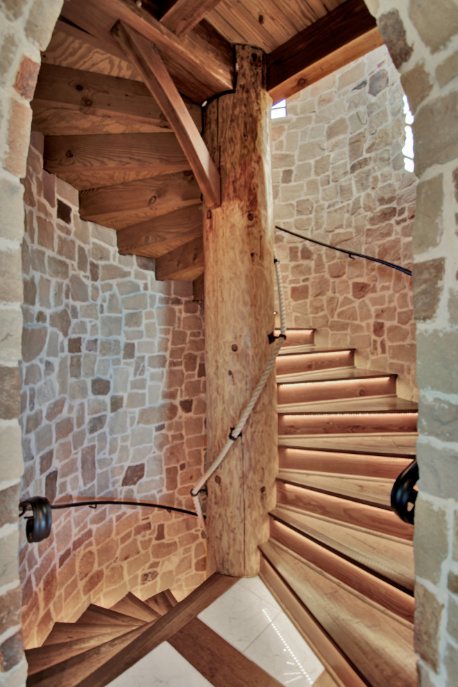 Réalisation d'un grand escalier hélicoïdal sud-ouest américain avec des marches en bois, des contremarches en bois et un garde-corps en métal.