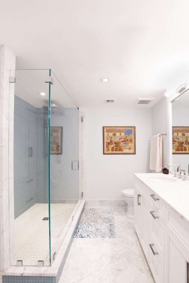 На фото: главная ванная комната в стиле фьюжн с фасадами в стиле шейкер, белыми фасадами, угловым душем, синей плиткой, стеклянной плиткой, мраморным полом, врезной раковиной, мраморной столешницей, белым полом, душем с распашными дверями, белой столешницей, тумбой под две раковины и встроенной тумбой с