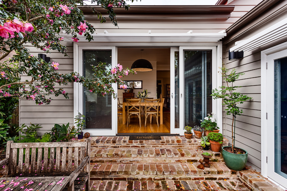 Inspiration for a mid-sized traditional one-storey beige exterior in Sydney with wood siding and a hip roof.