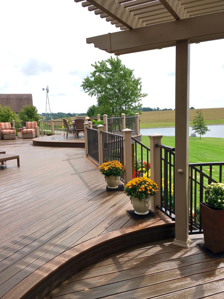 Large trendy backyard deck photo with a pergola