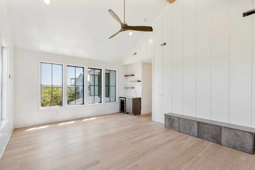 Modernes Hauptschlafzimmer mit weißer Wandfarbe, hellem Holzboden, freigelegten Dachbalken und Holzdielenwänden in Charleston