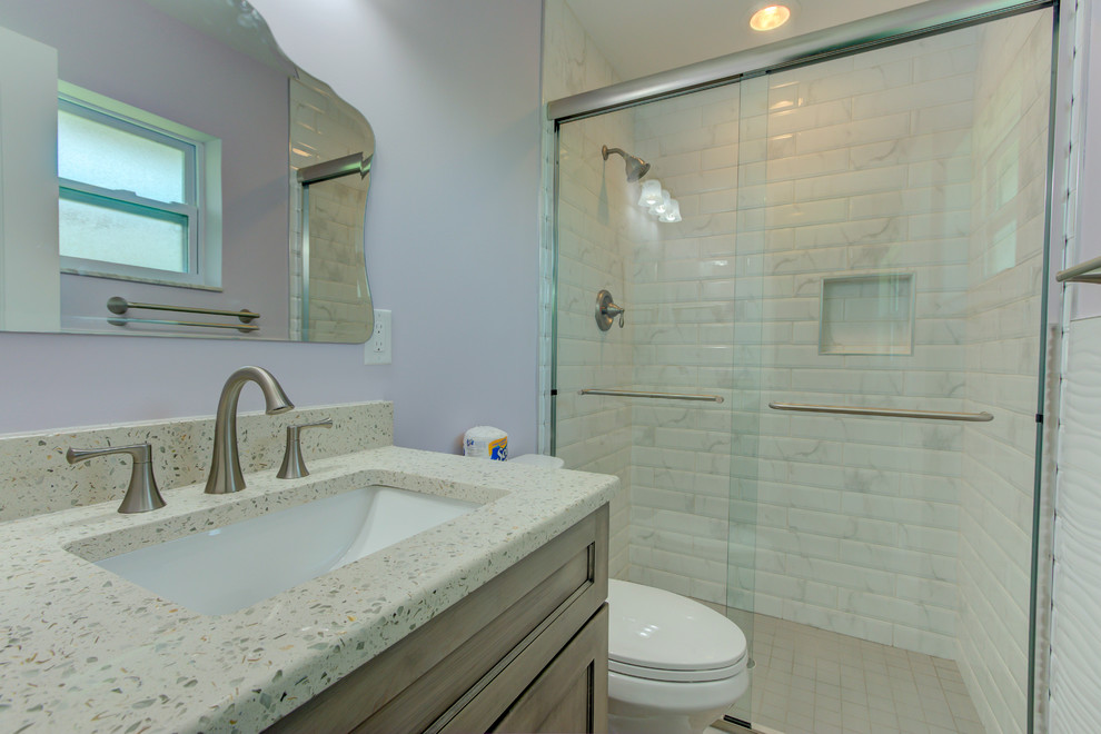 Aménagement d'une petite salle de bain principale classique avec un placard en trompe-l'oeil, des portes de placard grises, un plan de toilette en verre recyclé et un plan de toilette blanc.