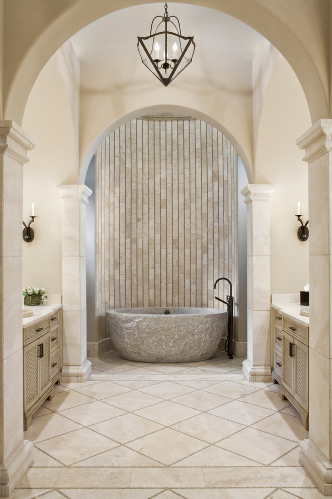 Expansive mediterranean master bathroom in Houston with recessed-panel cabinets, beige cabinets, a freestanding tub, beige tile, beige walls, an alcove shower, stone tile, travertine floors and beige floor.