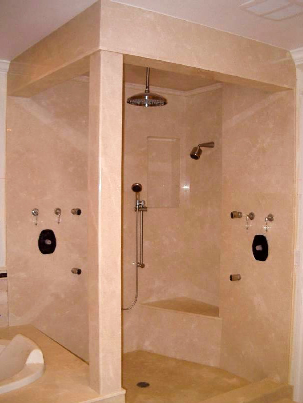 This is an example of a large traditional master bathroom in New York with a corner shower and beige tile.