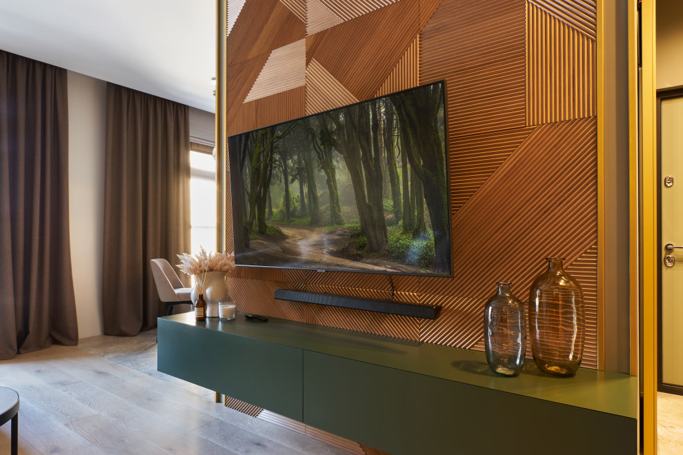 Offenes Modernes Wohnzimmer mit grüner Wandfarbe, braunem Holzboden, Kaminumrandung aus Holz, TV-Wand, braunem Boden und Holzwänden in Sonstige