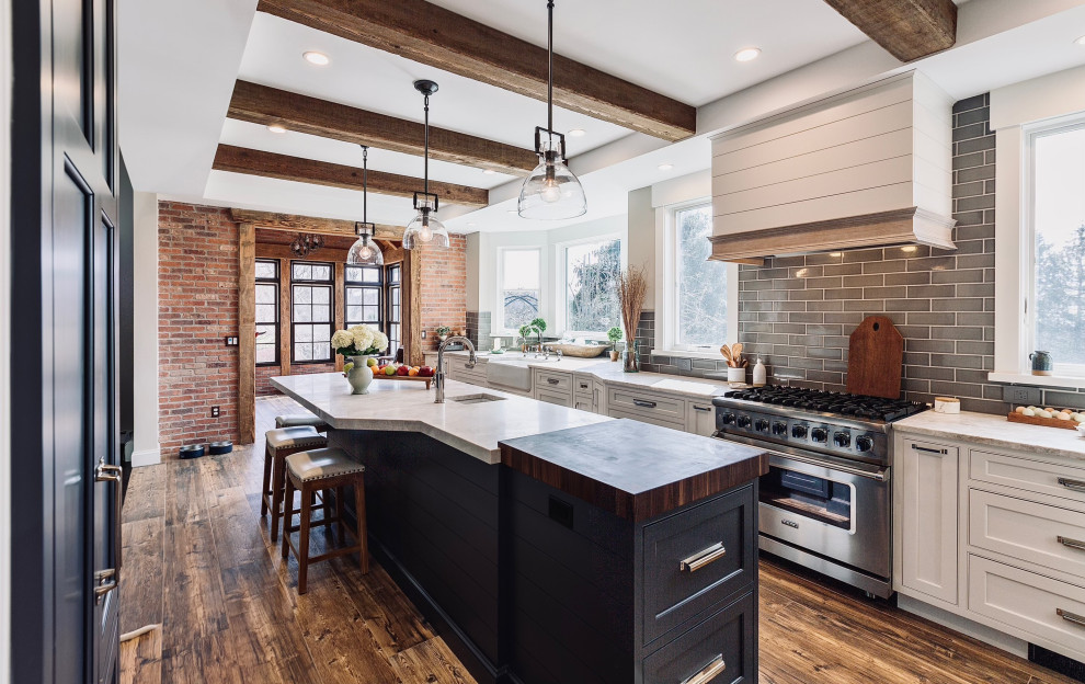 Inspiration for a large transitional kitchen in Other with a farmhouse sink, beaded inset cabinets, white cabinets, granite benchtops, stainless steel appliances, with island, brown floor and white benchtop.