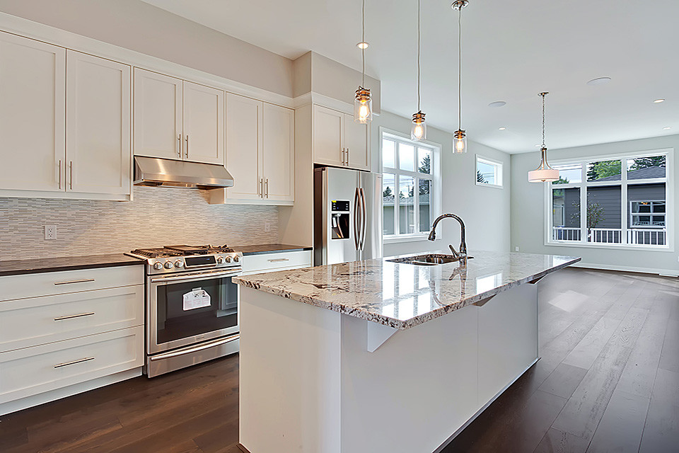 Inspiration for a large contemporary l-shaped eat-in kitchen in Calgary with shaker cabinets, white cabinets, granite benchtops, grey splashback, matchstick tile splashback, stainless steel appliances, dark hardwood floors, with island and an undermount sink.