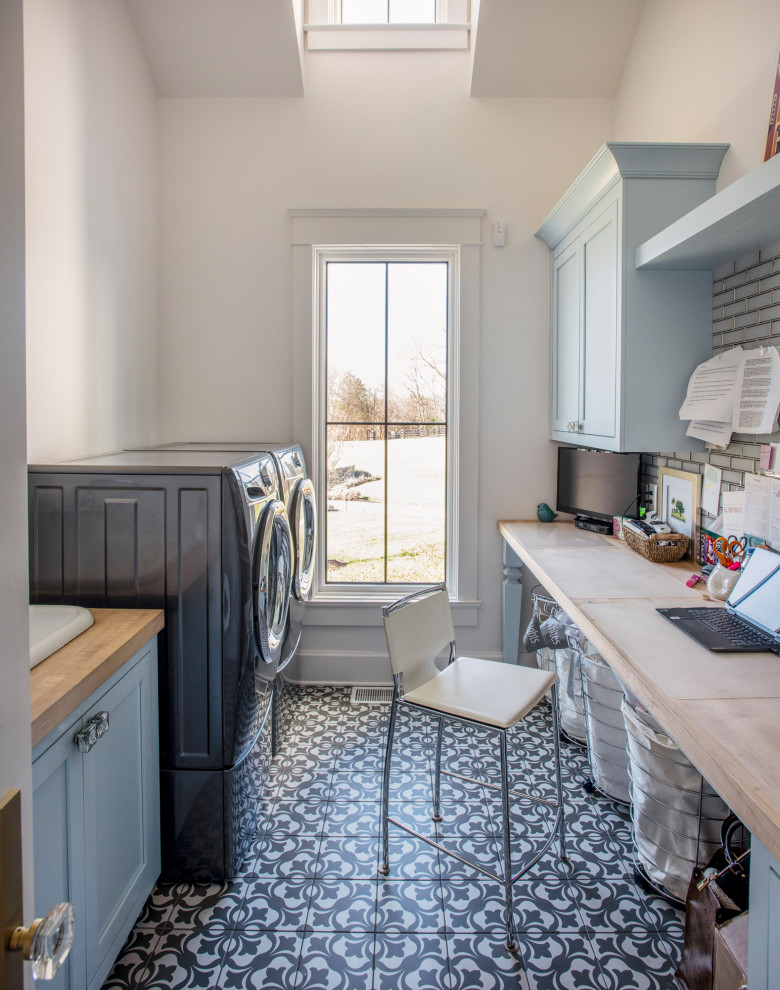 This is an example of a country galley utility room in Nashville with a drop-in sink, beaded inset cabinets, green cabinets, wood benchtops, grey splashback, ceramic splashback, white walls, ceramic floors, a side-by-side washer and dryer, white floor, blue benchtop and vaulted.