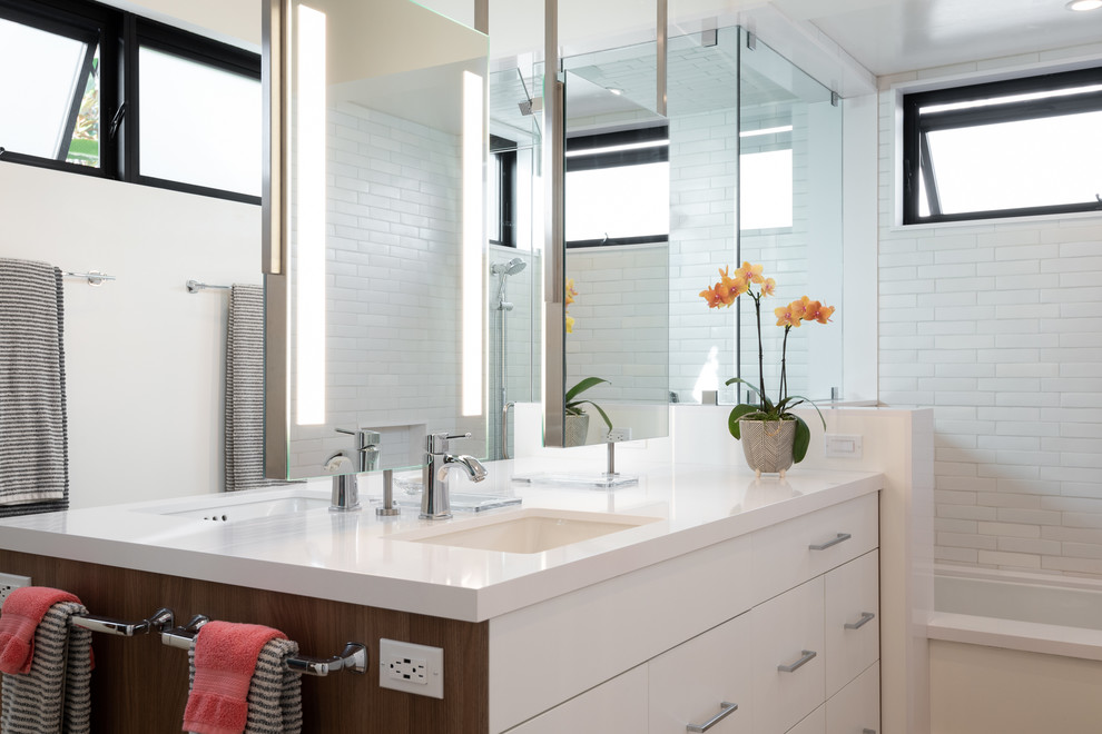 Design ideas for a mid-sized master bathroom in San Diego with flat-panel cabinets, white cabinets, an undermount tub, a curbless shower, a one-piece toilet, white tile, ceramic tile, white walls, cement tiles, an undermount sink, engineered quartz benchtops, a hinged shower door and white benchtops.