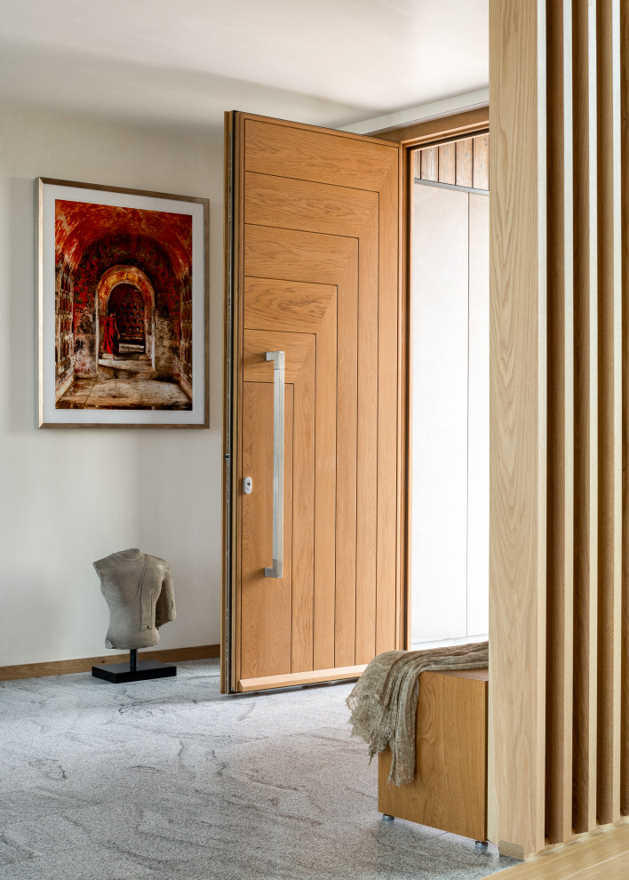 Diseño de distribuidor actual grande con paredes beige, suelo de granito, puerta simple, puerta de madera en tonos medios y suelo gris