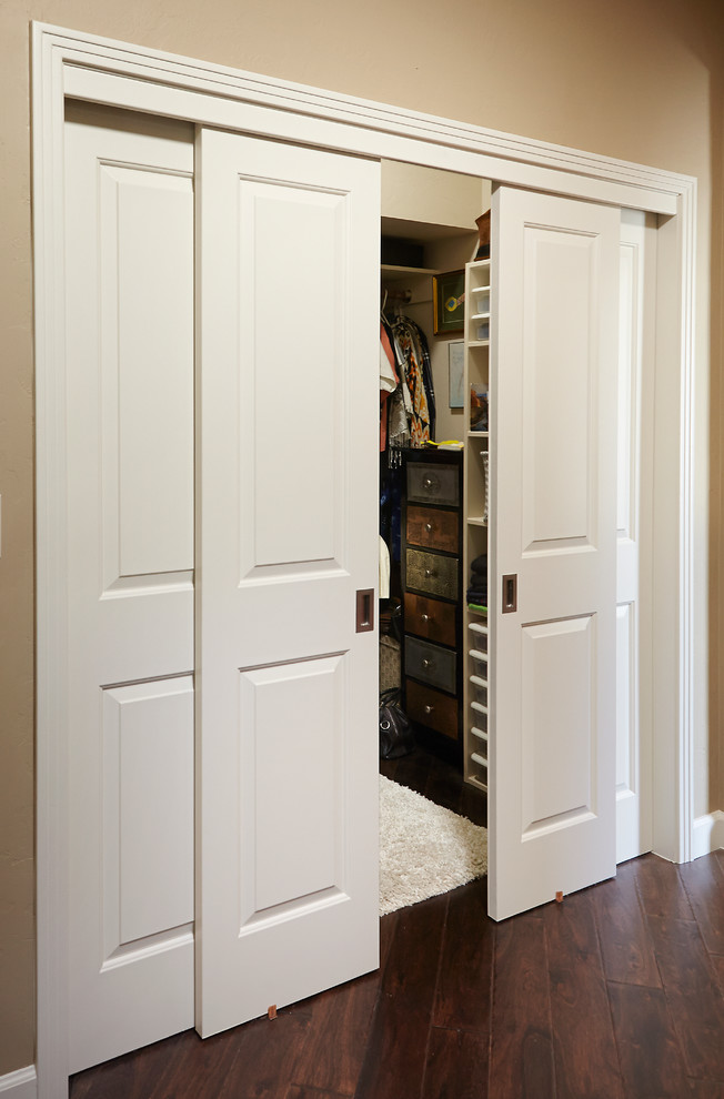 This is an example of a transitional walk-in wardrobe in Phoenix with raised-panel cabinets and dark hardwood floors.