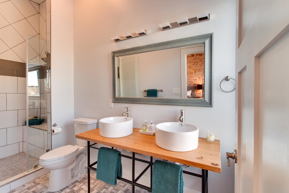 Bathroom - mid-sized transitional 3/4 gray tile and stone tile porcelain tile bathroom idea in DC Metro with a vessel sink, a two-piece toilet, gray walls, wood countertops and brown countertops