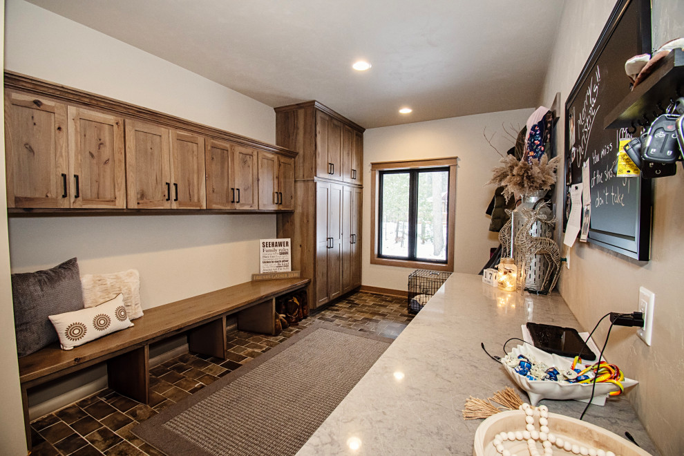 Inspiration for a large rustic ceramic tile and multicolored floor mudroom remodel with beige walls