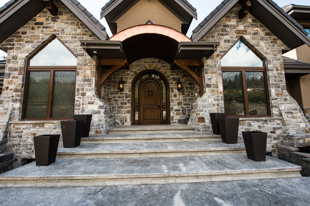 Example of a large mountain style front door design with a dark wood front door