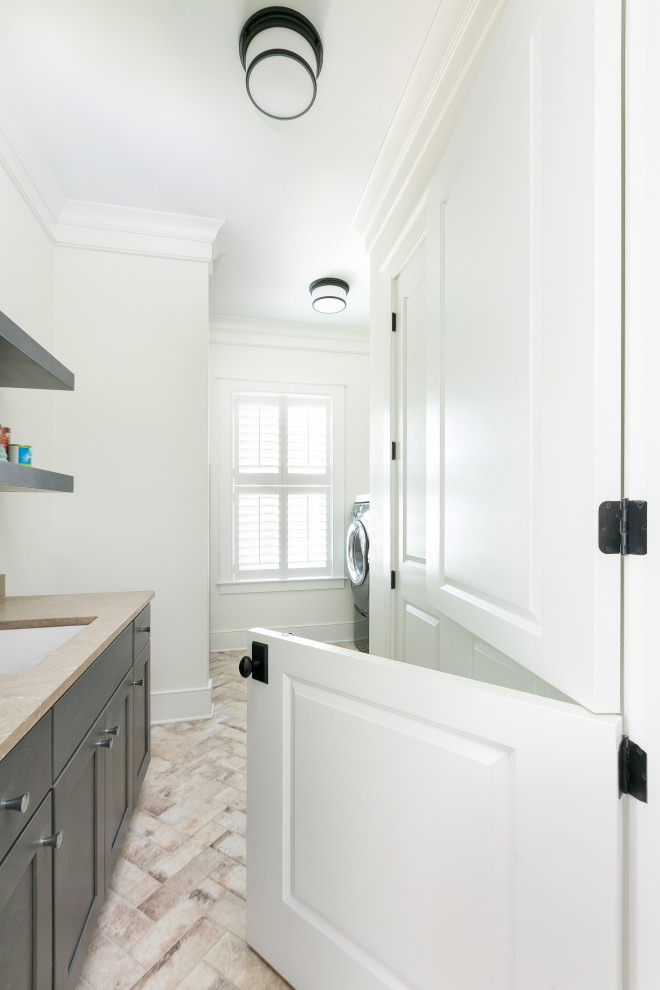 Design ideas for a mid-sized transitional galley dedicated laundry room in Charleston with an undermount sink, shaker cabinets, dark wood cabinets, quartz benchtops, beige walls, porcelain floors, a side-by-side washer and dryer, multi-coloured floor and beige benchtop.