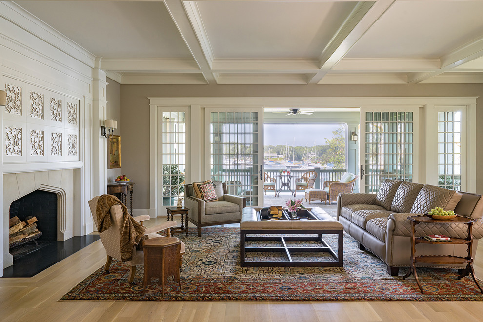 This is an example of a beach style formal open concept living room in Boston with beige walls, light hardwood floors, a standard fireplace, a tile fireplace surround and beige floor.