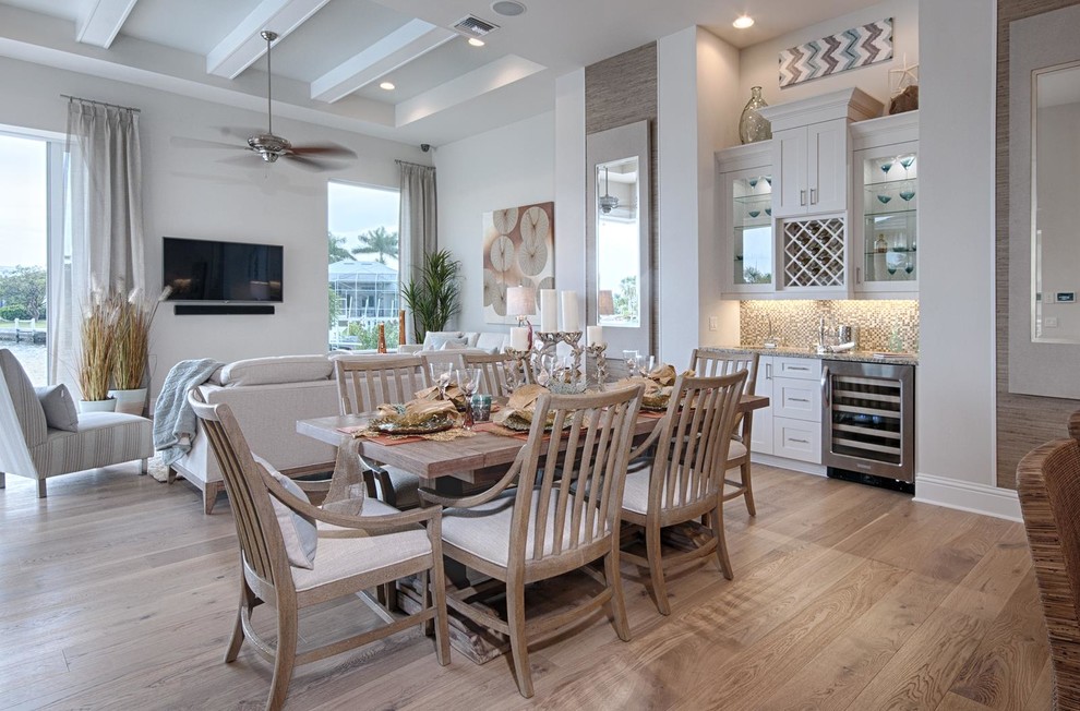 This is an example of a beach style open plan dining in Miami with medium hardwood floors, beige walls and no fireplace.