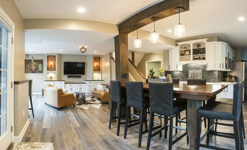 Inspiration for a mid-sized country look-out basement in Columbus with beige walls, medium hardwood floors, no fireplace and grey floor.