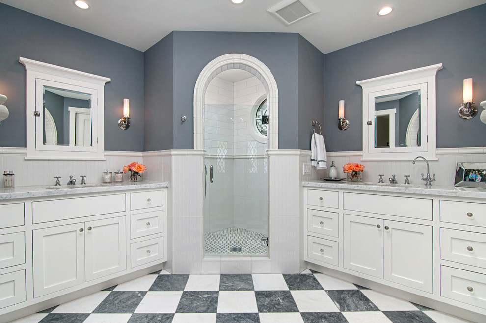 Photo of a large traditional master bathroom in San Diego with beaded inset cabinets, white cabinets, a freestanding tub, a corner shower, white tile, porcelain tile, blue walls, porcelain floors, a drop-in sink and marble benchtops.