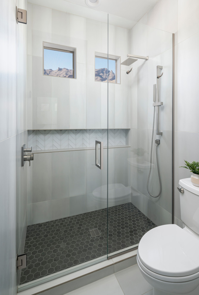 Immagine di una stanza da bagno contemporanea con ante lisce, ante in legno chiaro, un lavabo e mobile bagno sospeso