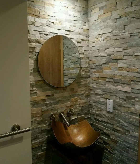 This is an example of a mid-sized mediterranean powder room in New York with a wall-mount sink, grey walls and ceramic floors.