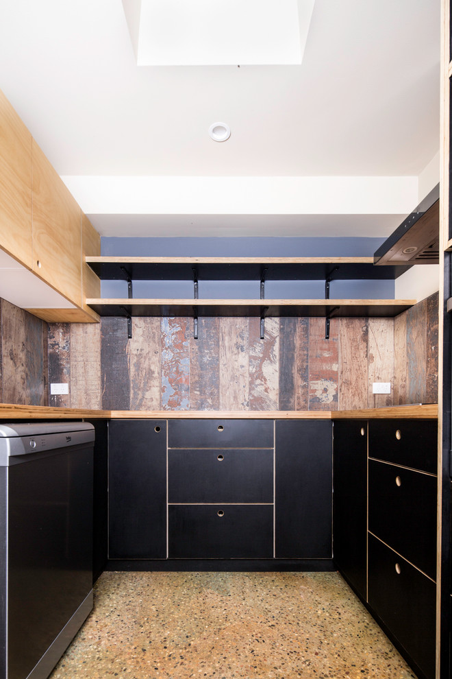 This is an example of a small industrial u-shaped kitchen in Brisbane with flat-panel cabinets, black cabinets, wood benchtops and concrete floors.