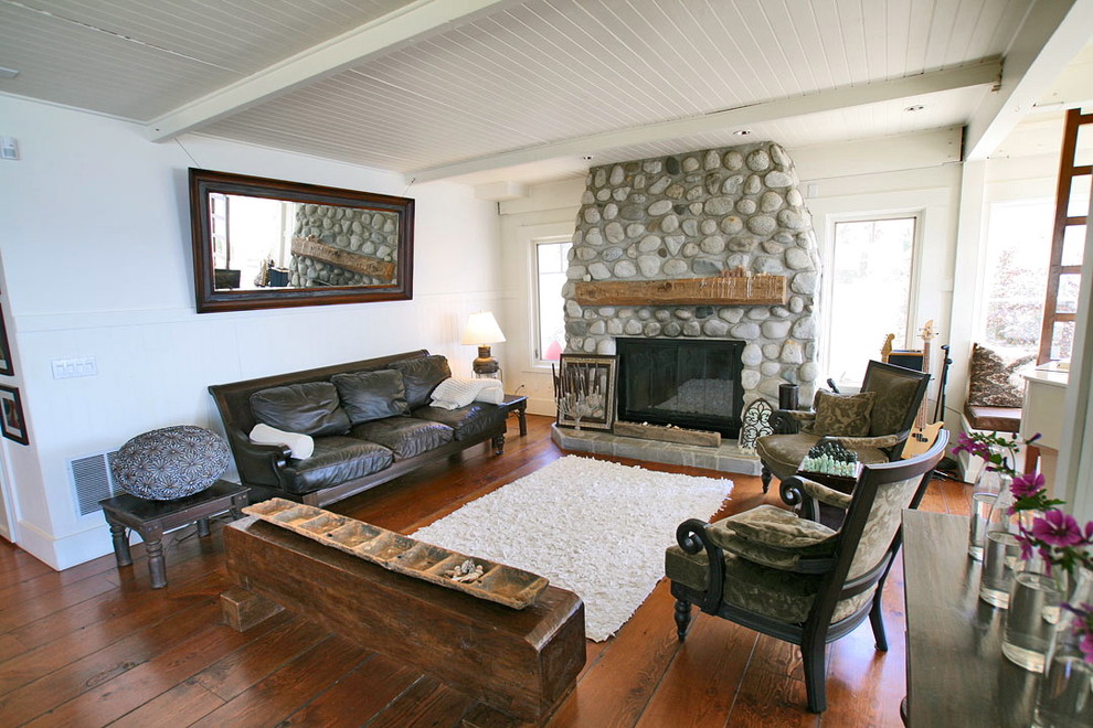 This is an example of a mid-sized beach style formal open concept living room in Seattle with white walls, medium hardwood floors, a standard fireplace, a stone fireplace surround and no tv.