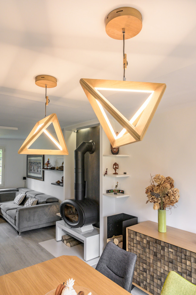 Foto di un soggiorno design di medie dimensioni e aperto con pareti bianche, parquet chiaro, stufa a legna, pavimento beige e soffitto ribassato
