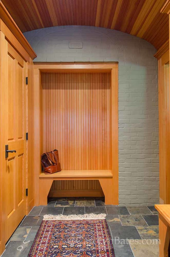 This is an example of a traditional mudroom in Burlington with white walls and slate floors.