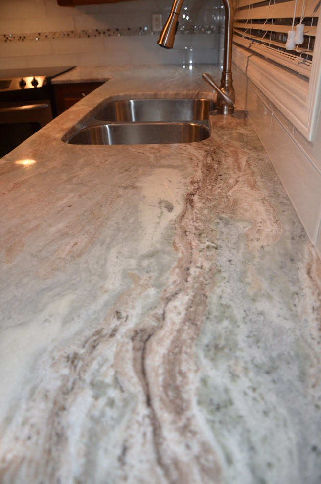 Inspiration for a small transitional u-shaped porcelain tile home design remodel in Toronto with a double-bowl sink, beaded inset cabinets, medium tone wood cabinets, granite countertops, white backsplash, glass tile backsplash, stainless steel appliances and no island