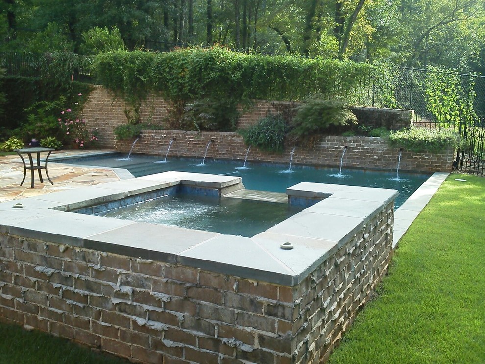 Example of a large transitional backyard custom-shaped and stone natural hot tub design in Atlanta