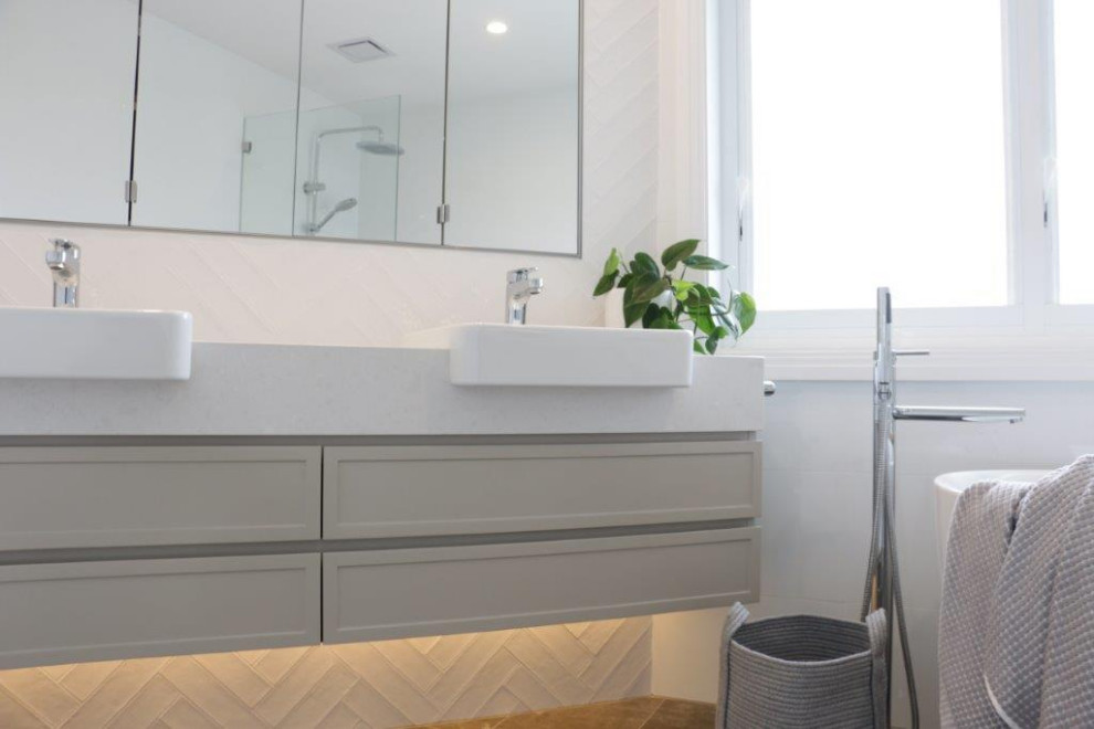 Mid-sized contemporary master bathroom in Sydney with shaker cabinets, grey cabinets, a freestanding tub, an open shower, a one-piece toilet, white tile, porcelain tile, white walls, cement tiles, engineered quartz benchtops, grey floor, an open shower, white benchtops, a double vanity and a floating vanity.