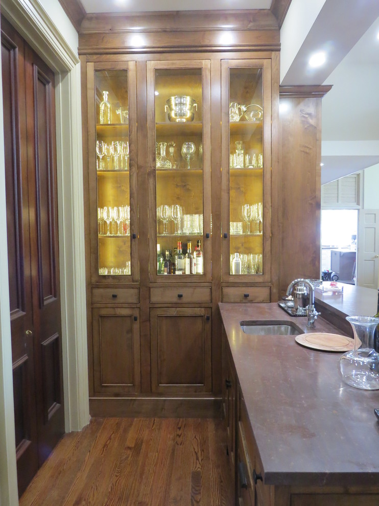 This is an example of a mid-sized transitional single-wall seated home bar in DC Metro with an undermount sink, recessed-panel cabinets, medium wood cabinets, soapstone benchtops and medium hardwood floors.