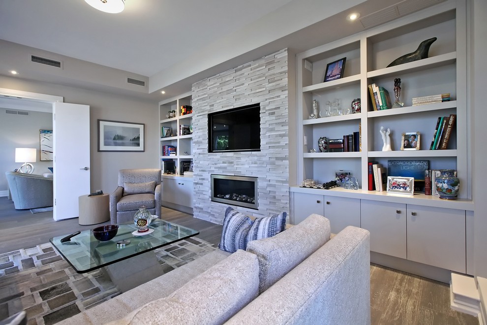 Large contemporary open concept family room in Toronto with grey walls, dark hardwood floors, a ribbon fireplace, a stone fireplace surround, a built-in media wall and brown floor.