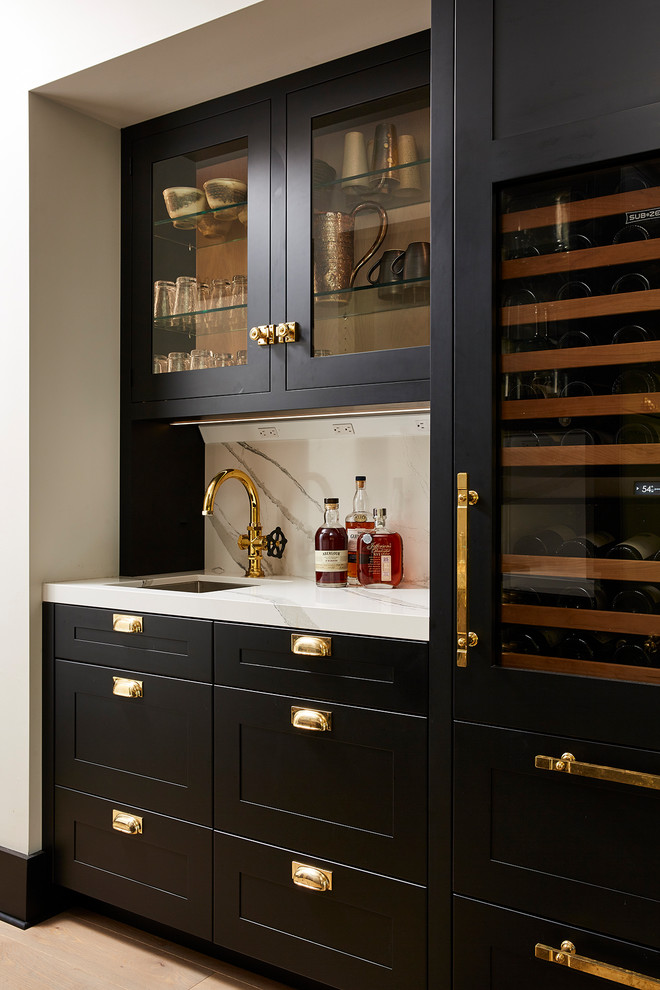 Transitional single-wall light wood floor wet bar photo in Minneapolis with an undermount sink, shaker cabinets, black cabinets, quartz countertops, white backsplash, stone slab backsplash and white countertops