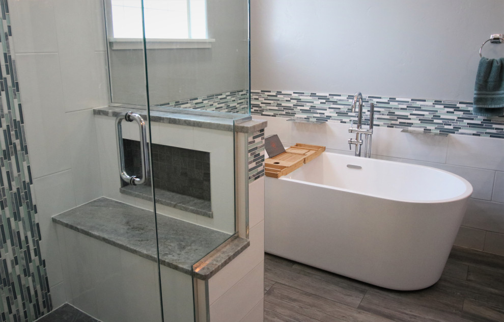 Large master bathroom in Other with blue cabinets, a freestanding tub, multi-coloured tile, ceramic tile, porcelain floors, marble benchtops, brown floor, multi-coloured benchtops, a shower seat, a double vanity, a corner shower and a hinged shower door.