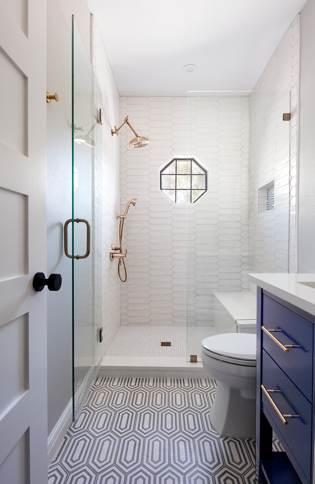 Small transitional 3/4 bathroom in Austin with flat-panel cabinets, blue cabinets, an alcove shower, white tile, an undermount sink, multi-coloured floor, a hinged shower door, white benchtops, porcelain tile, cement tiles and solid surface benchtops.
