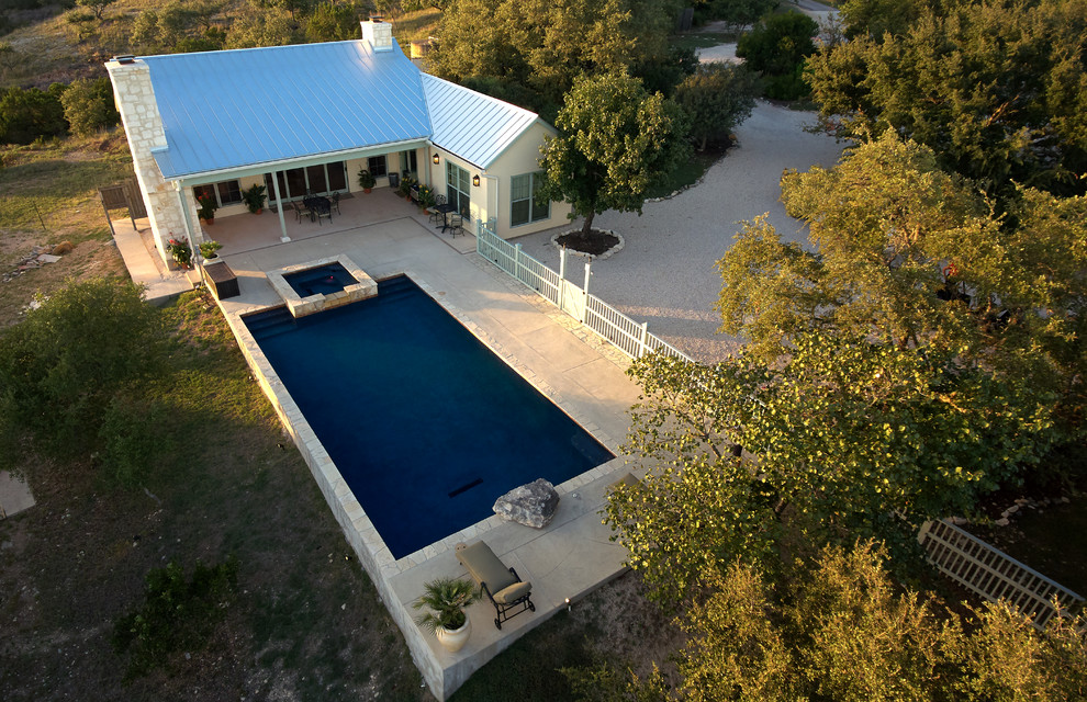 Hot tub - mid-sized rustic backyard stamped concrete and rectangular natural hot tub idea in Austin