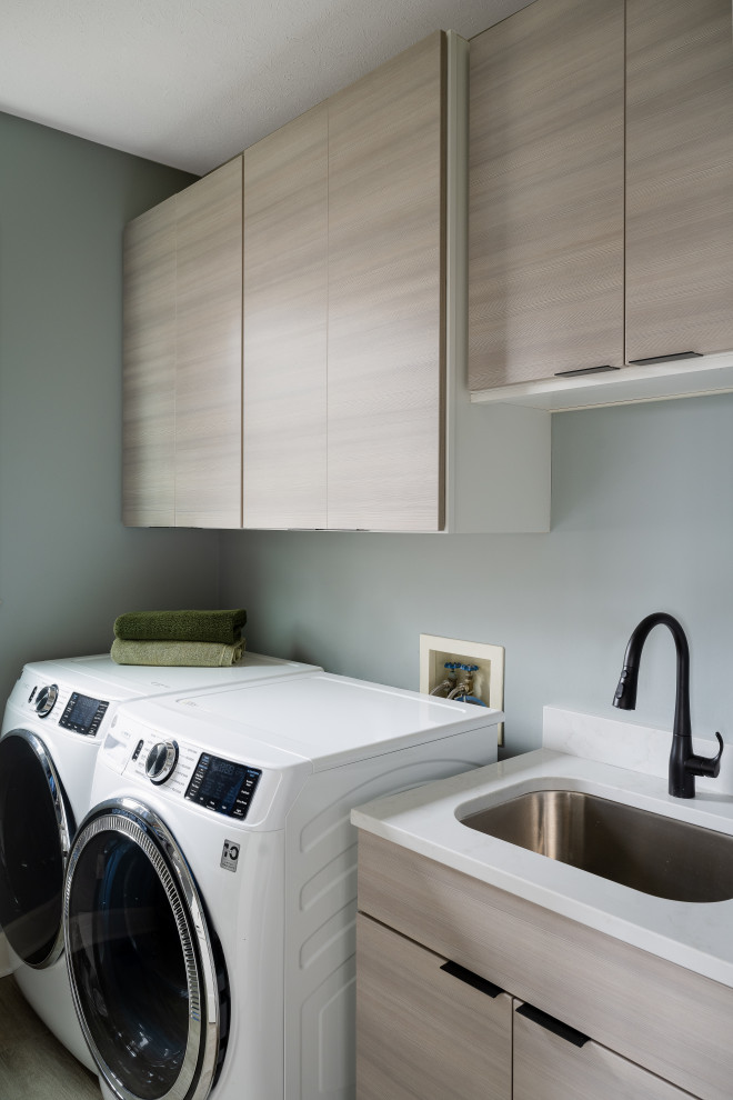 Idéer för mellanstora funkis parallella tvättstugor enbart för tvätt, med en undermonterad diskho, släta luckor, skåp i ljust trä och en tvättmaskin och torktumlare bredvid varandra