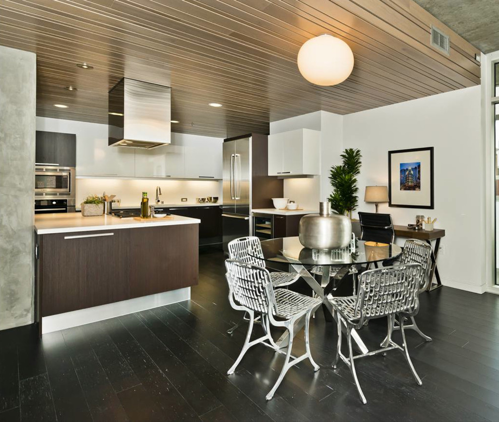 This is an example of a mid-sized contemporary u-shaped open plan kitchen in San Francisco with stainless steel appliances, dark hardwood floors, an integrated sink, flat-panel cabinets, dark wood cabinets, quartz benchtops, white splashback and with island.