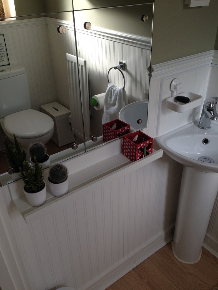 This is an example of a mid-sized traditional bathroom in West Midlands with glass-front cabinets, white cabinets and green walls.