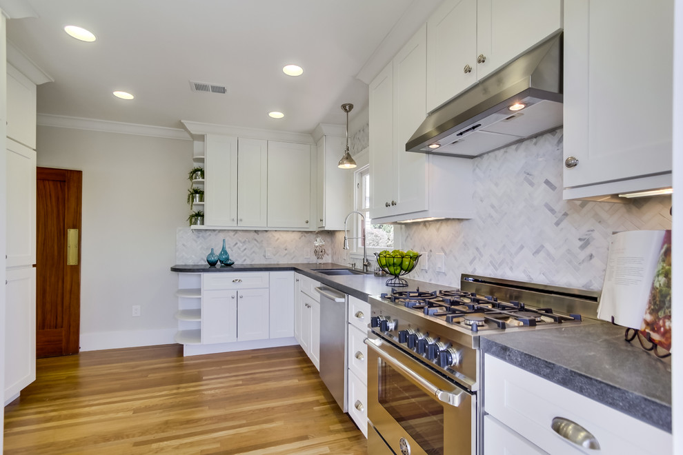 Design ideas for a mid-sized arts and crafts l-shaped separate kitchen in San Diego with a single-bowl sink, shaker cabinets, white cabinets, granite benchtops, white splashback, mosaic tile splashback, stainless steel appliances, light hardwood floors and no island.