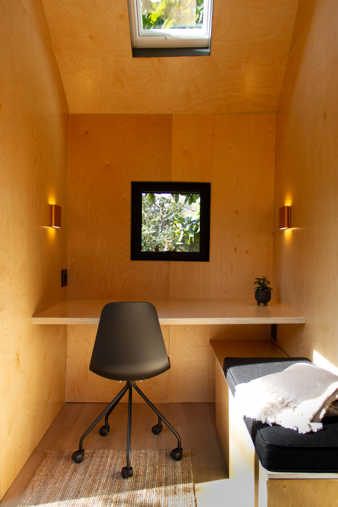 Свежая идея для дизайна: маленькое рабочее место в стиле модернизм с коричневыми стенами, полом из винила, встроенным рабочим столом, коричневым полом, сводчатым потолком и деревянными стенами для на участке и в саду - отличное фото интерьера